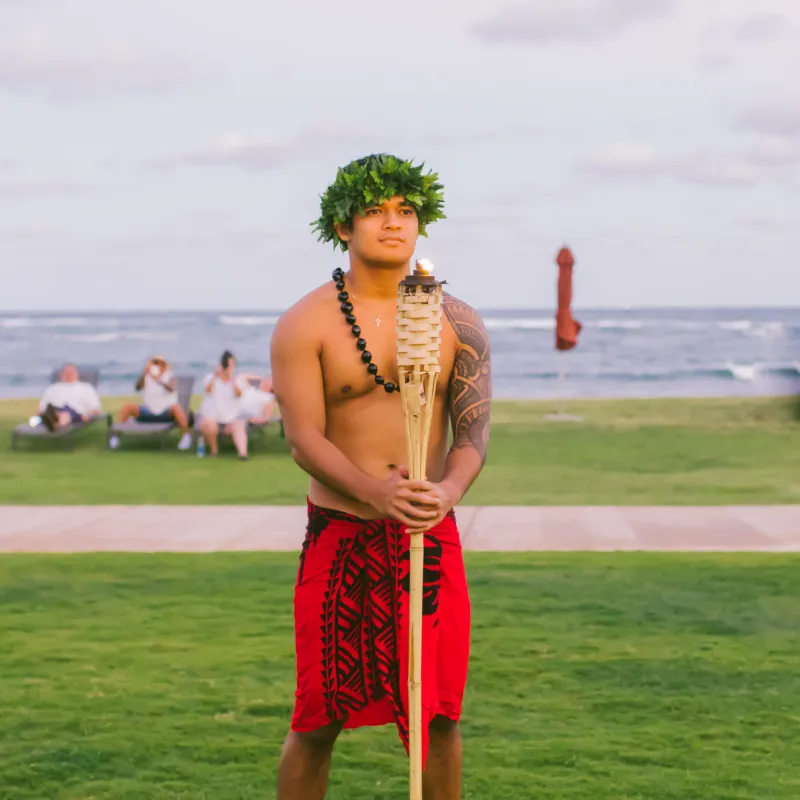 a person holding a frisbee in front of a body of water